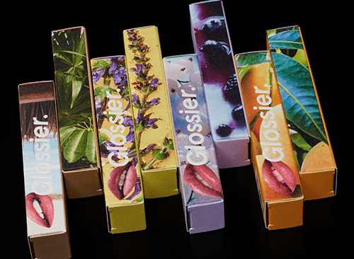 Glossier lipstick boxes with images from nature and vibrant colors.